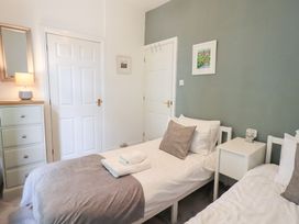 A bedroom with two single beds and a dresser at Drystones in Grasmere