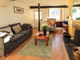 A living room with a sofa, armchair, and television at Buttonhole Cottage in Ambleside
