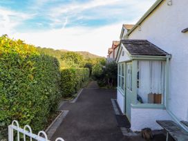 A pathway bordered by hedges with a house at Sunbeam Cottage in Coniston