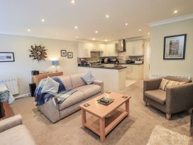 A living room with sofas and a kitchen in Lakeland Loft Windermere