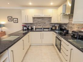 A kitchen with cabinets, sink, oven, microwave, and kettle at Lakeland Loft in Windermere
