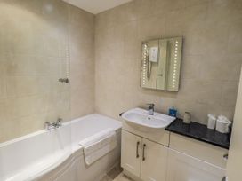 A bathroom with a bathtub and sink at Lakeland Loft in Windermere