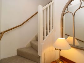 A staircase with a handrail and a lamp at Chapel How, Ambleside