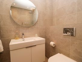 A bathroom with a sink, toilet, and mirror at Chapel How in Ambleside