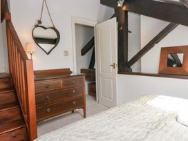 A bedroom with a dresser and a staircase at Chapel How in Ambleside