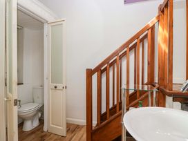 A bathroom with a toilet and sink adjacent to a staircase at Chapel How Ambleside