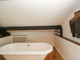 A bathroom with a bathtub and radiator at Chapel How in Ambleside