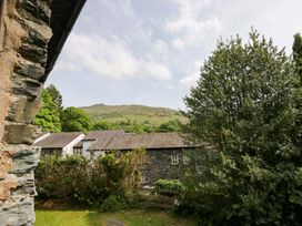 A view of houses and trees with a hill in the background at Chapel How Ambleside