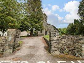 A church with stone walls and trees at Chapel How in Ambleside