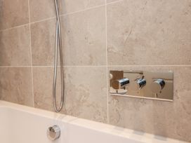 A bathtub with a showerhead and faucet controls at Chapel How Ambleside