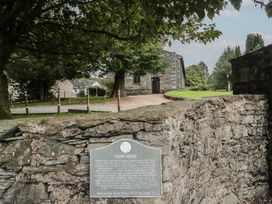An outdoor area with a stone wall and an information plaque at Chapel How in Ambleside
