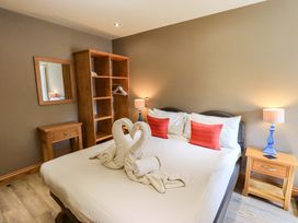 A bedroom with a bed and wooden furniture at Abbots Reading Mews 1 in Grizedale