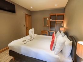 A bedroom with a bed and towels arranged at Abbots Reading Mews 1 in Grizedale