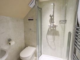 A bathroom with a shower, toilet, and sink at Abbots Reading Mews 1 in Grizedale