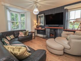 A living room with a sofa and television at Newby Bridge House in Newby Bridge
