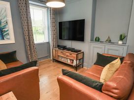 A living room with a television and sofa at Newby Bridge House in Newby Bridge