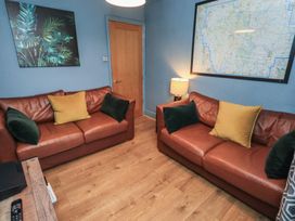 A living room with two sofas and a lamp at Newby Bridge House, Newby Bridge