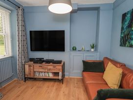 A living room with a television and sofa at Newby Bridge House in Newby Bridge
