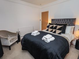A bedroom with a bed and armchair at Newby Bridge House in Newby Bridge