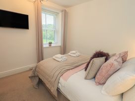 A bedroom with a bed and television at Newby Bridge House in Newby Bridge