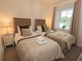 A bedroom with two single beds and a bedside table at Newby Bridge House in Newby Bridge