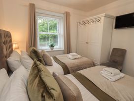 A bedroom with twin beds and a wardrobe at Newby Bridge House in Newby Bridge