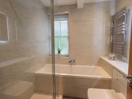 A bathroom with bathtub and sink at Newby Bridge House in Newby Bridge