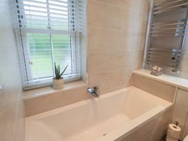 A bathroom featuring a bathtub and a window at Newby Bridge House in Newby Bridge