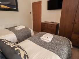 A bedroom with two beds and a television at Newby Bridge House in Newby Bridge