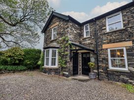 A stone building with an entrance and plants near the door at Newby Bridge House in Newby Bridge