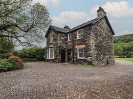 A house with a gravel driveway and garden at Newby Bridge House in Newby Bridge