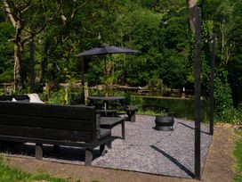 An outdoor seating area with a bench and a table at Newby Bridge House in Newby Bridge