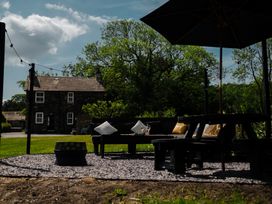 A garden with seating and a house in the background at Newby Bridge House in Newby Bridge