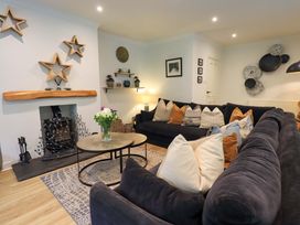 A living room with a sofa, coffee table, and fireplace at Underheron in Grasmere