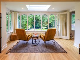 A conservatory with two armchairs and a side table at Underheron in Grasmere