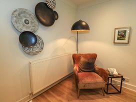 A living room with a chair and side table at Underheron in Grasmere