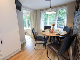 A dining room with a table set and a television at Underheron in Grasmere
