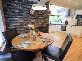 A dining room with a round table and chairs at Underheron in Grasmere