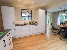 A kitchen with cabinets and a table at Underheron in Grasmere