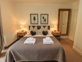 A bedroom with a bed and framed artwork at Underheron in Grasmere