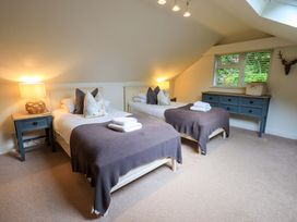 A bedroom with two beds and a dresser at Underheron in Grasmere