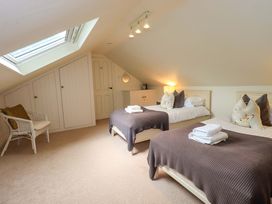 A bedroom with two beds and a chair at Underheron in Grasmere