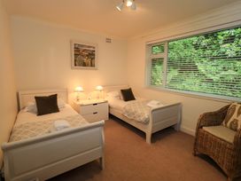 A bedroom with twin beds and a chair at Underheron in Grasmere