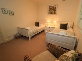 A bedroom with two single beds and bedside lamps at Underheron in Grasmere