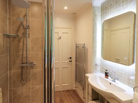 A bathroom with a shower, sink, and towel radiator at Underheron in Grasmere