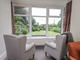 A snug with chairs and window overlooking garden at Miyanli in Bowness
