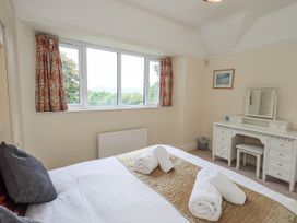 A bedroom with a bed and a vanity table at Miyanli in Bowness