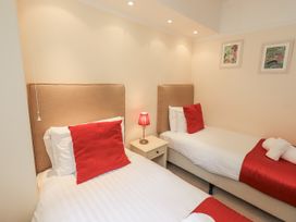 A bedroom with two beds and a lamp on a nightstand at Miyanli in Bowness