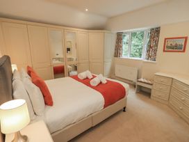 A bedroom with a bed and a dressing table at Miyanli in Bowness