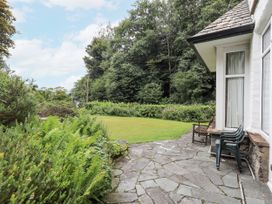 A garden with stone path and chairs at Miyanli in Bowness